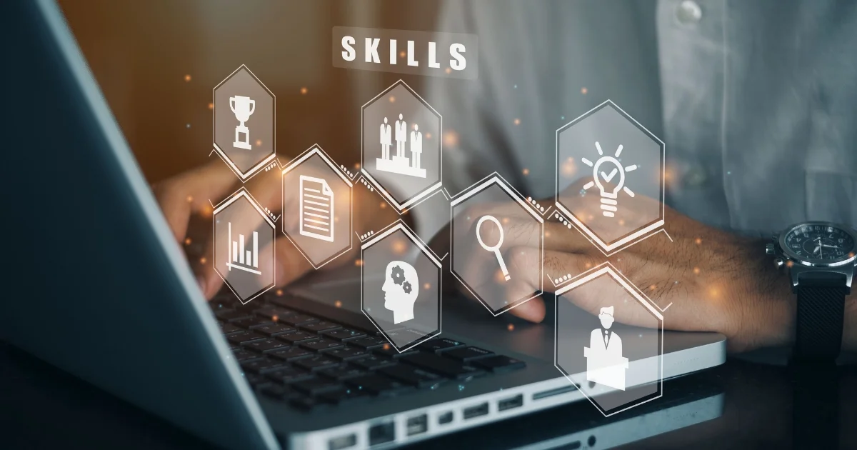 Hands typing on laptop with skill icons overlay.